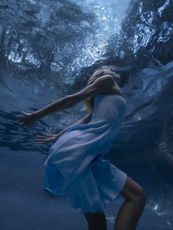Underwater fashion shot of a model wearing a blue dress