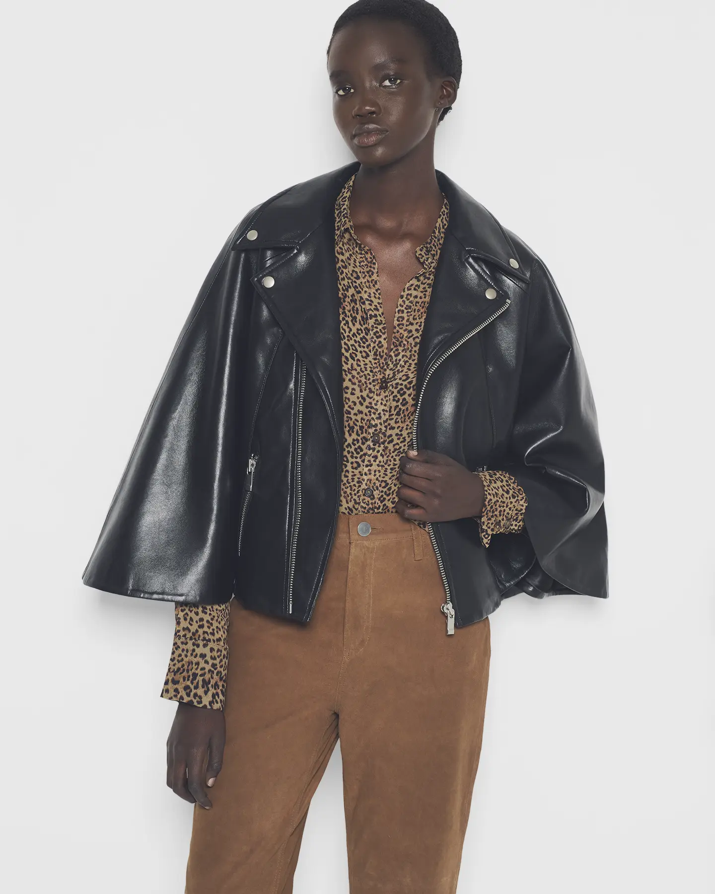 Detail view of the recycled leather moto cape in a studio setting