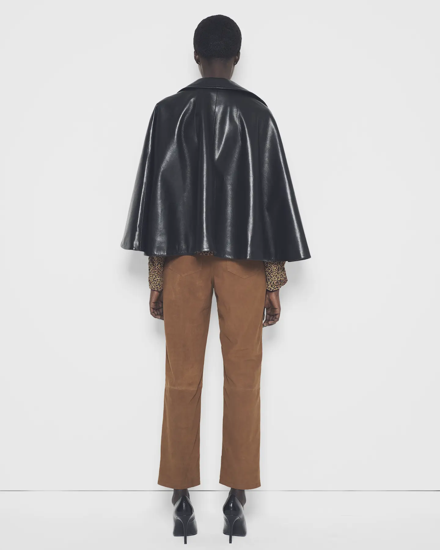 Back view of the recycled leather moto cape on a model in studio lighting