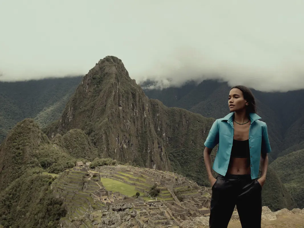 Model wearing a green jacket photographed near Machu Picchu